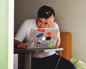 Frustrated man looking at his laptop. 